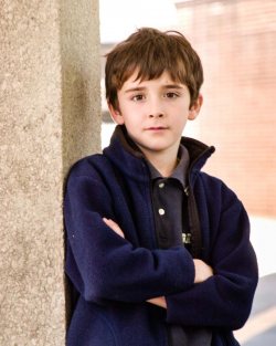 Outdoor Child Portrait of young boy with crossed arms, wearing a