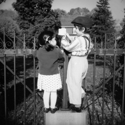 Outdoor Portrait of young boy and girl facing each other while r