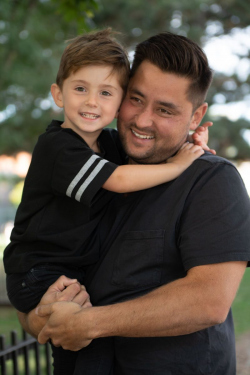Casual Portrait of a father holding his young son, both dressed