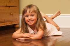 Casual Portrait of a young girl lying on the wooden floor of her