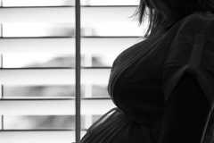 Silhoette in profile of an expectant mother in front of bright w